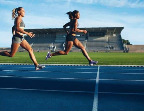 Athletes arrives at finish line on racetrack